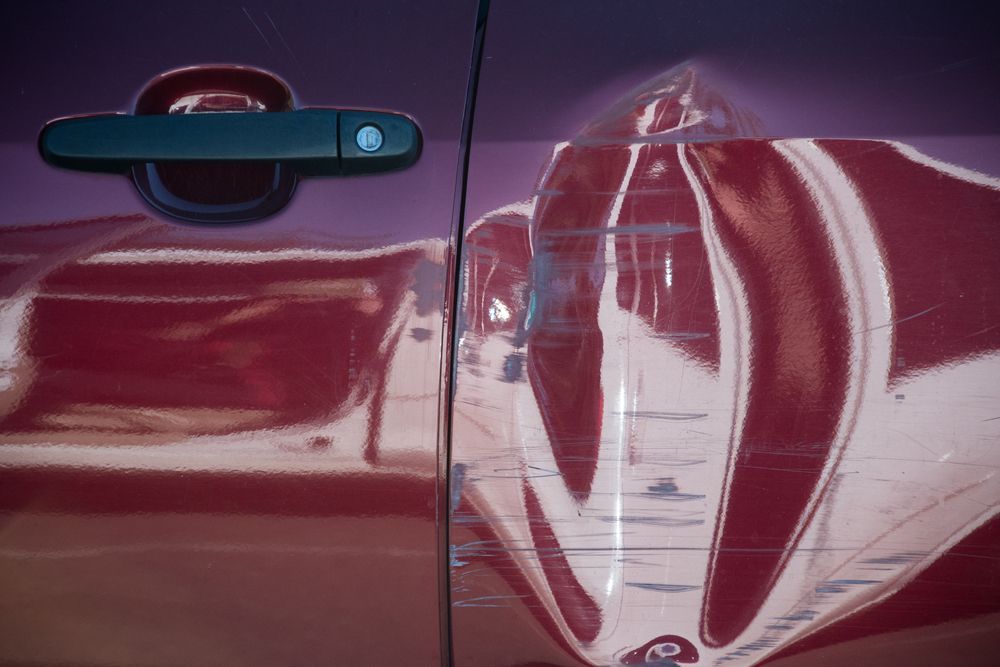 A Close Up of a Red Car Door With a Black Handle — C & C Panel & Paint Mackay In Mackay, QLD