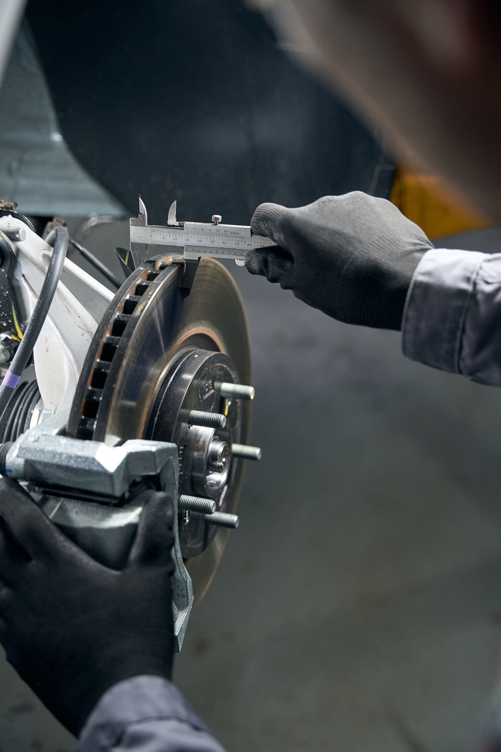 A mechanic measuring disc brake rotor for wear