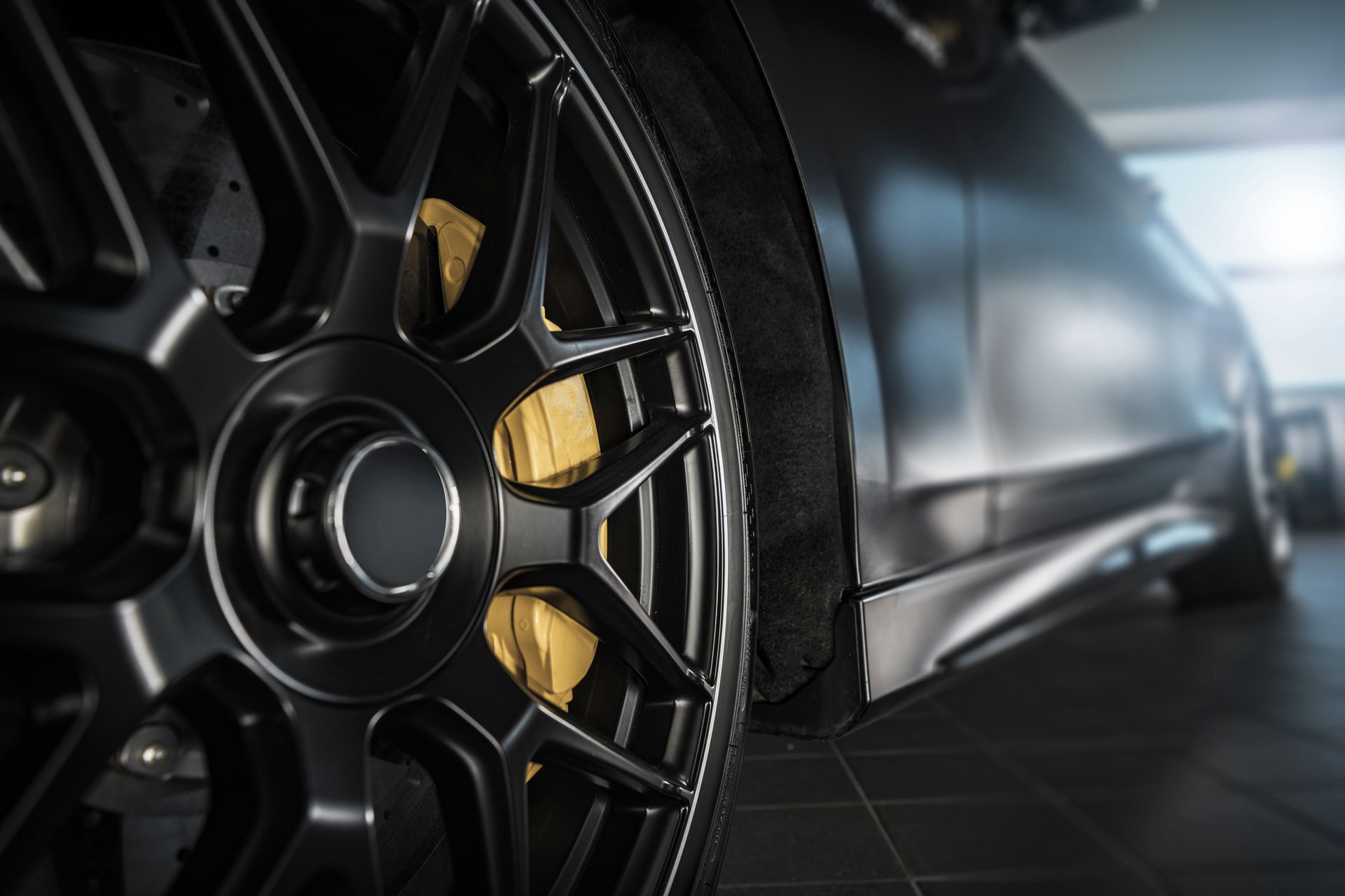 A close up of a car wheel with brake calipers on it.
