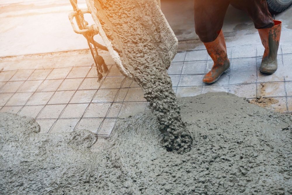 Pouring wet concrete onto a tiled surface at a construction site