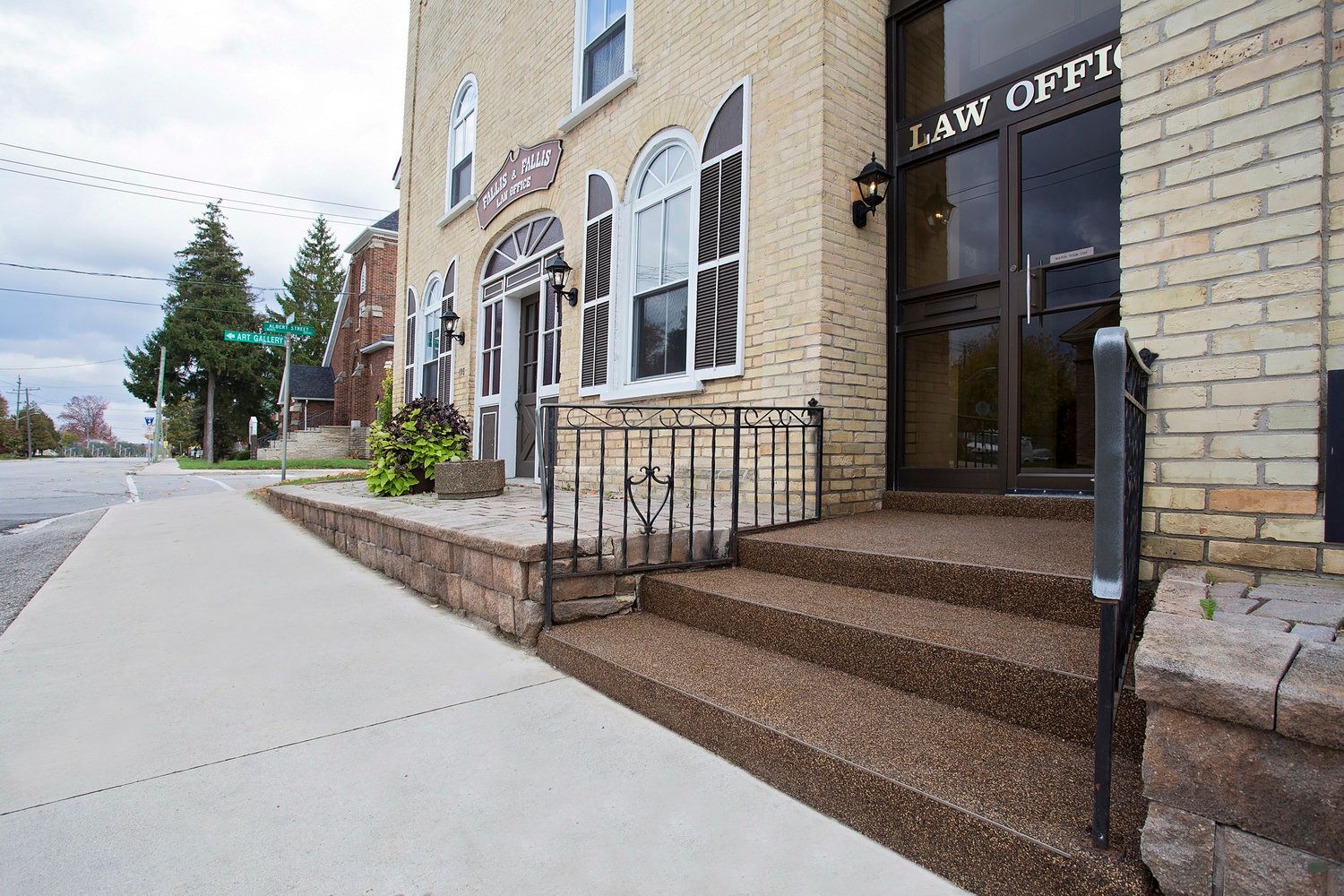 A brick building with stairs leading up to it and a sign that says law office