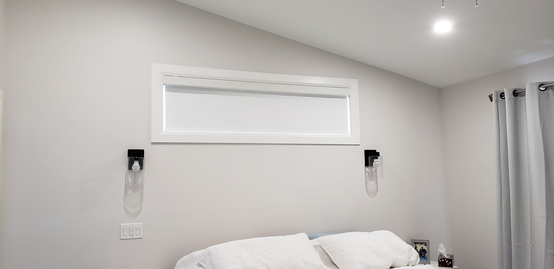 A bedroom with a bed , window and curtains.