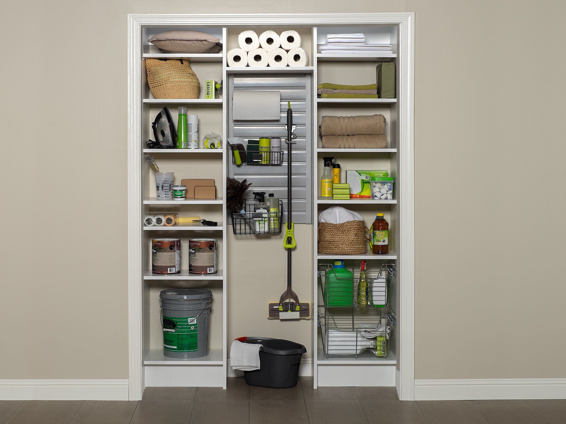 A closet filled with lots of cleaning supplies and a mop.