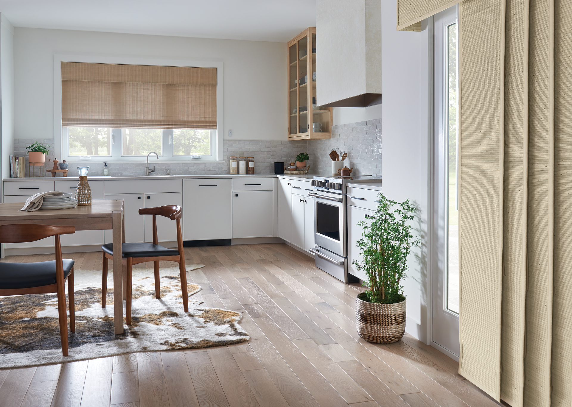 A kitchen with a table and chairs and a potted plant.