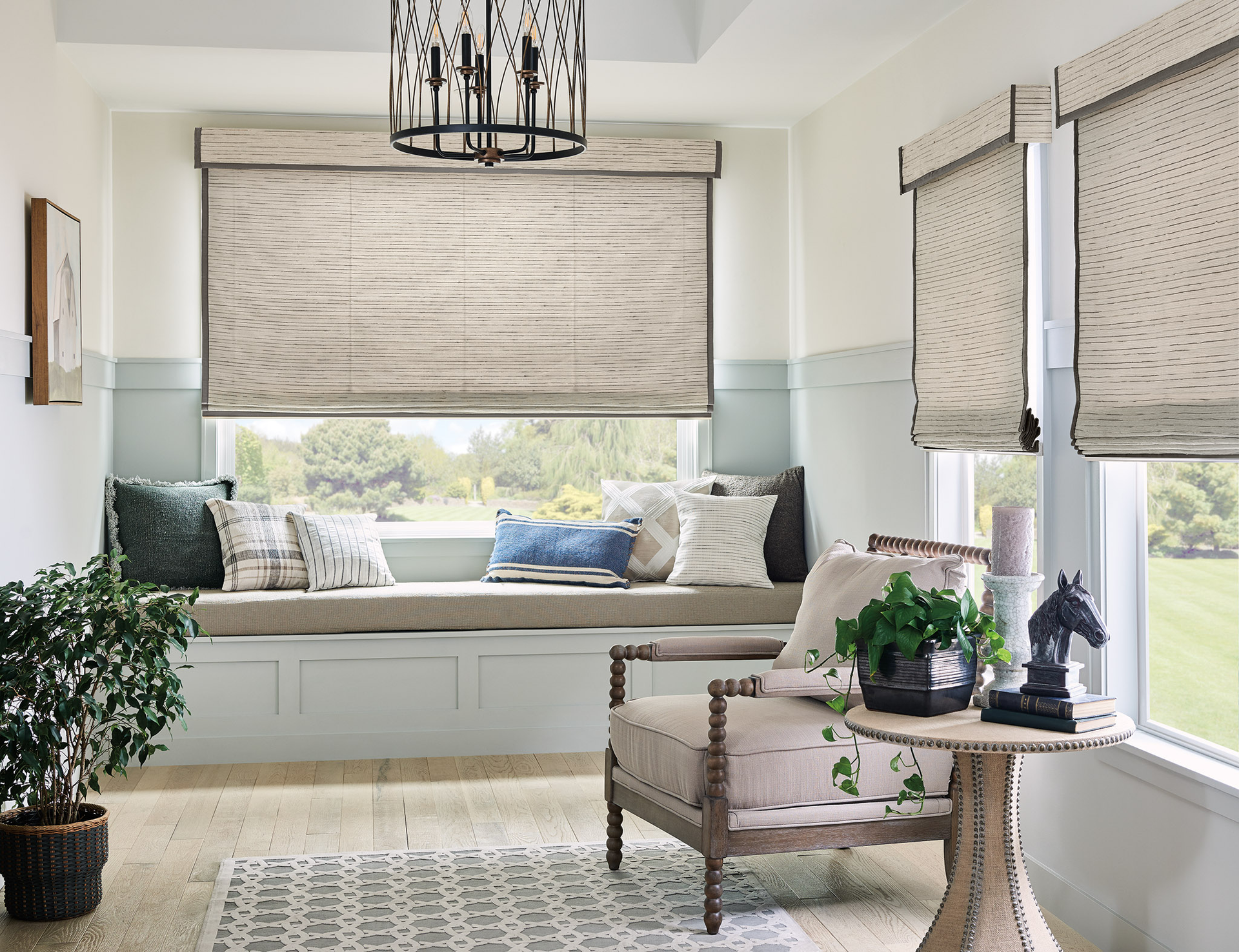 A living room with a window seat , chair , table and plants.