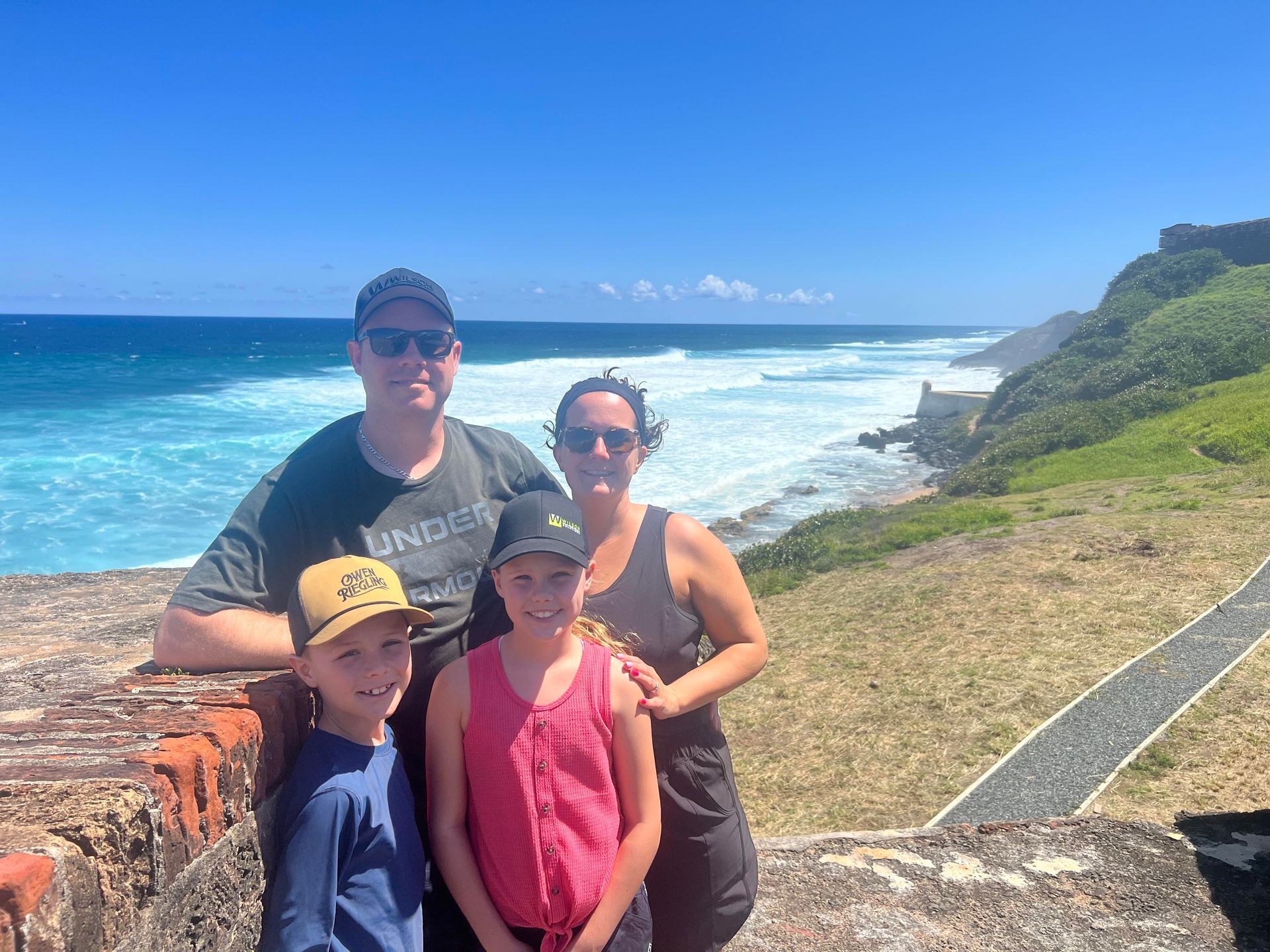 A family is posing for a picture in front of the ocean.