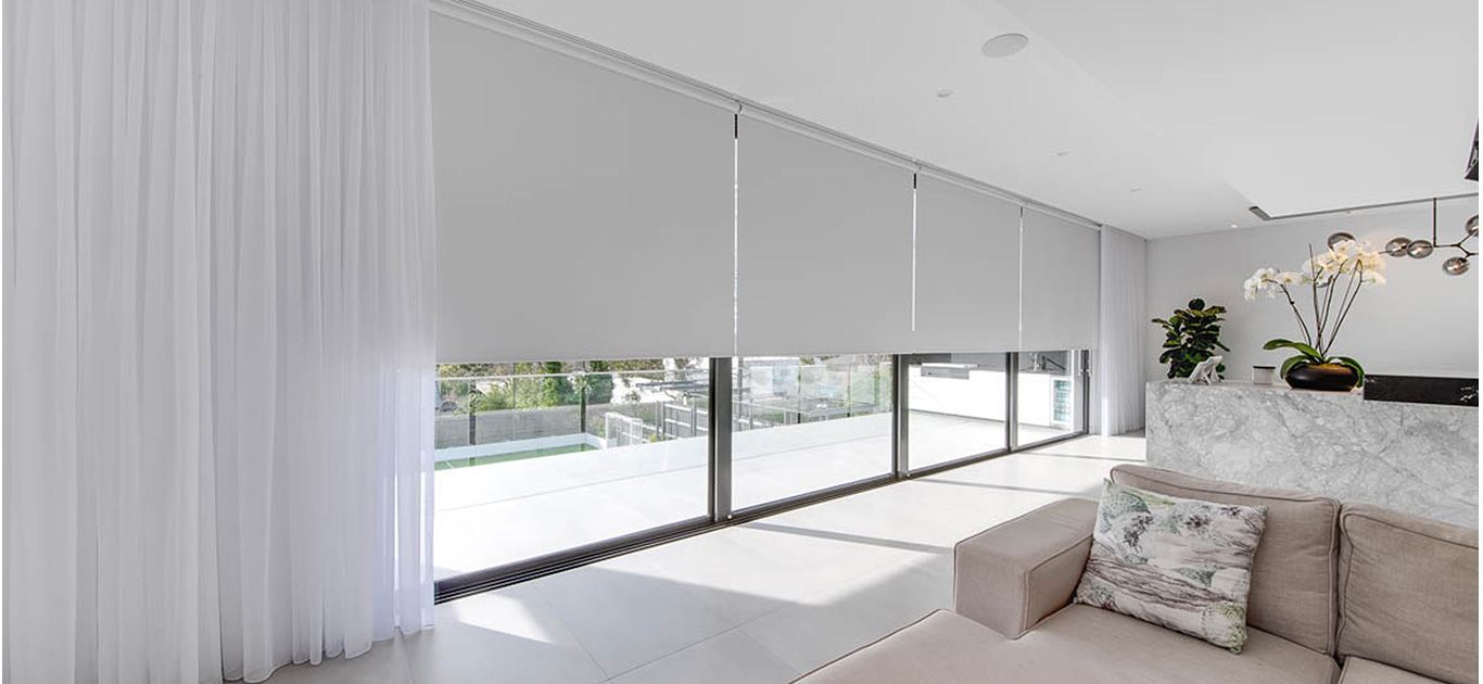 A living room with a couch , curtains and a large window.