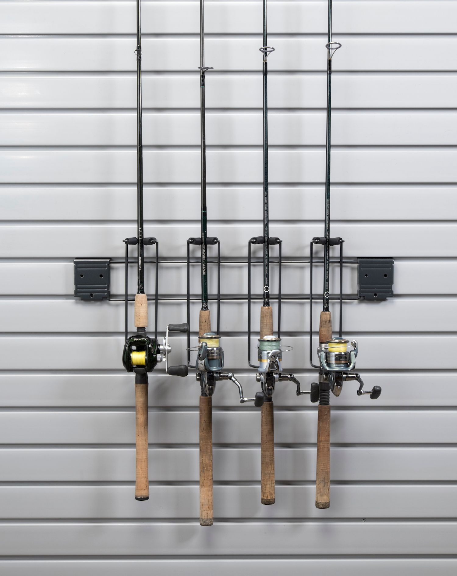 Four fishing rods mounted on a slat wall, held by black metal holders.