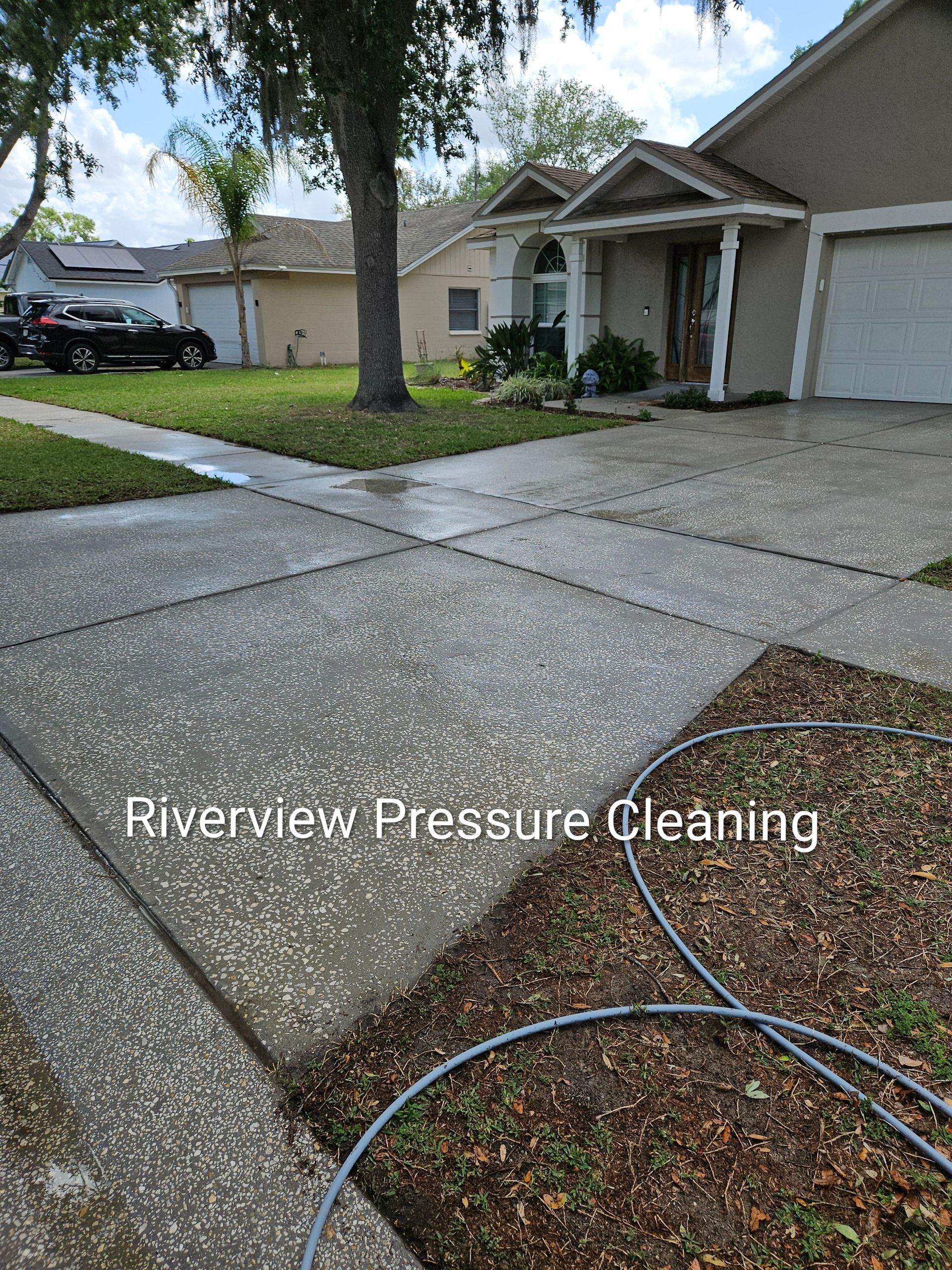 Driveway and sidewalk in a suburban home, with concrete being pressure cleaned.