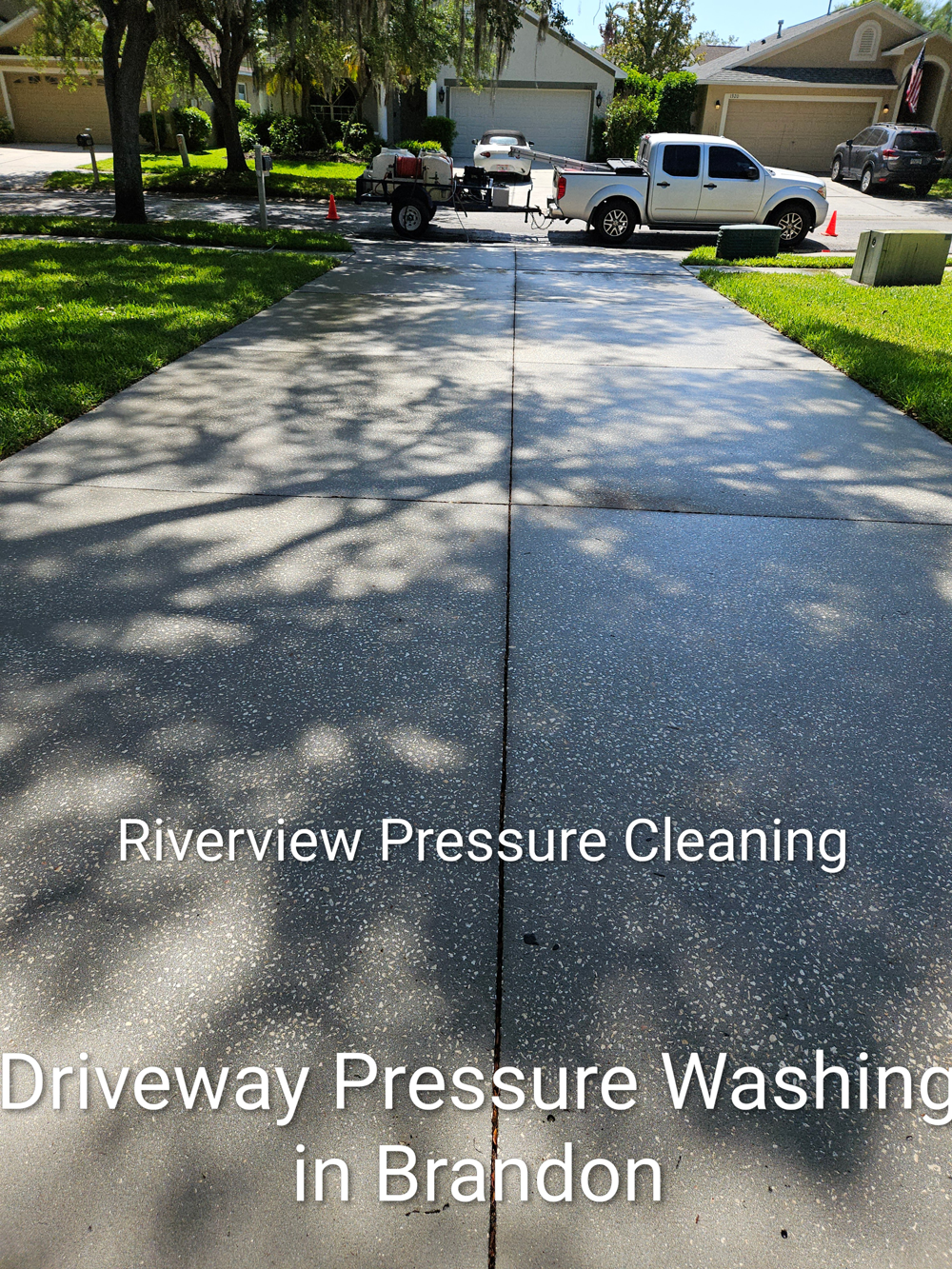 Pressure washing service cleaning a driveway in Brandon, with truck and equipment in the background