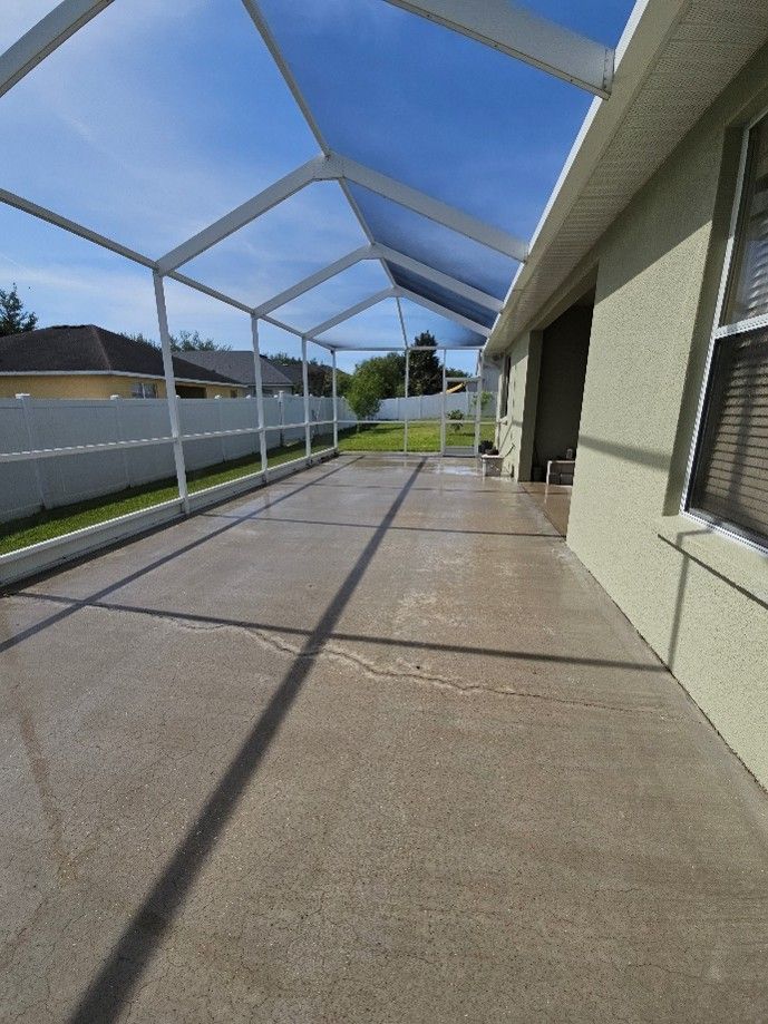 Dirty lanai cage and concrete with algae and pollen buildup in Valrico
