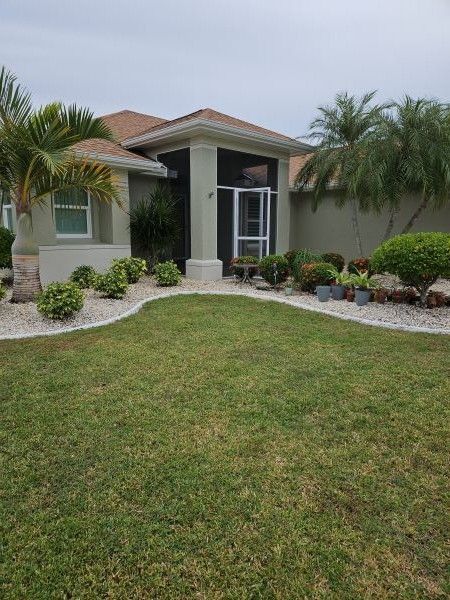 Single-story home with a landscaped front yard, palm trees, and a covered entryway.