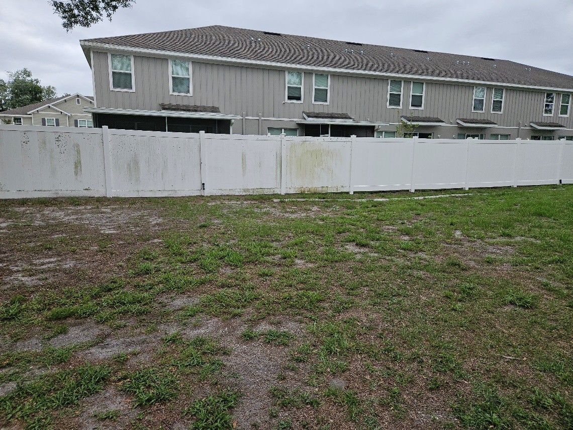 Vinyl fence in Riverview covered with heavy algae and lichen before professional fence pressure washing.