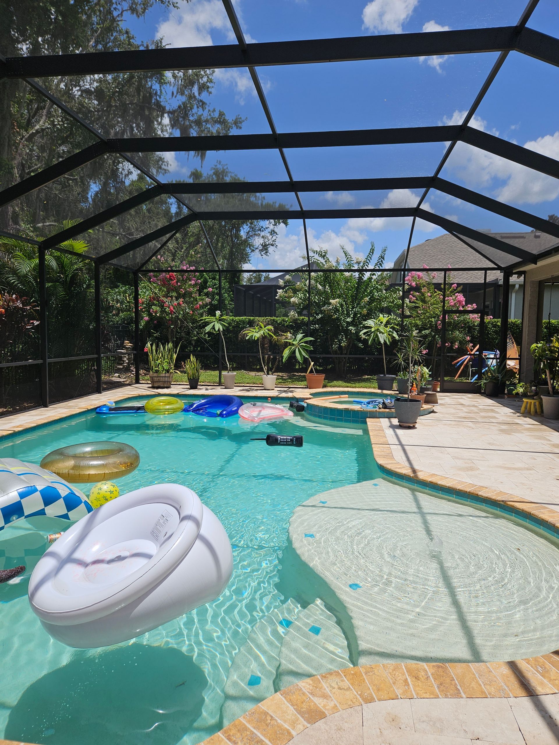 A screened in swimming pool with floats in it