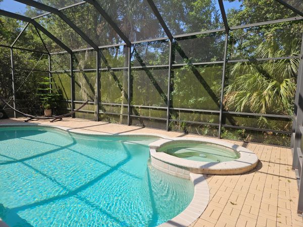 A large swimming pool with a hot tub underneath it.