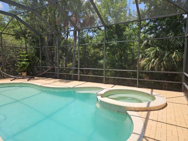 A large swimming pool with a hot tub in the middle of it.