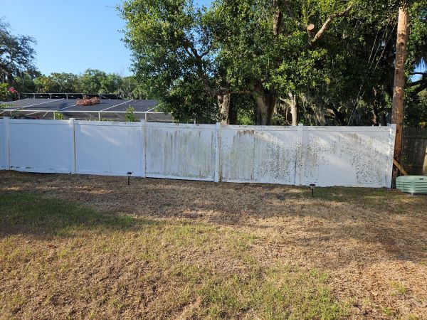 A white fence is sitting in the middle of a grassy yard.