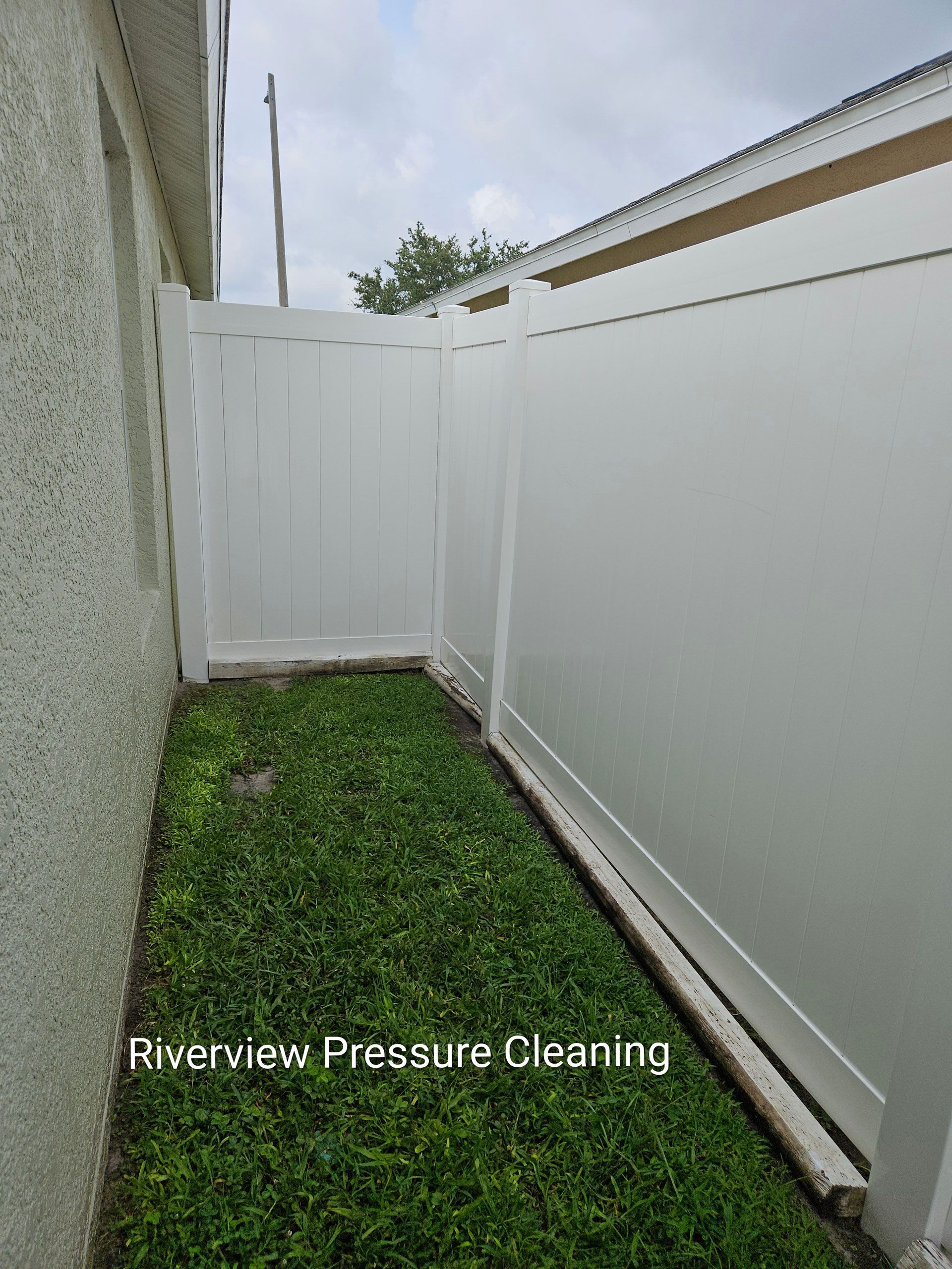 Clean white vinyl fence after professional pressure washing in Riverview