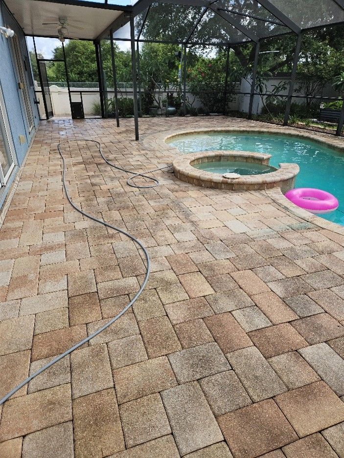 Backyard patio with brick pavers, screened enclosure, and small pool with pink floatie