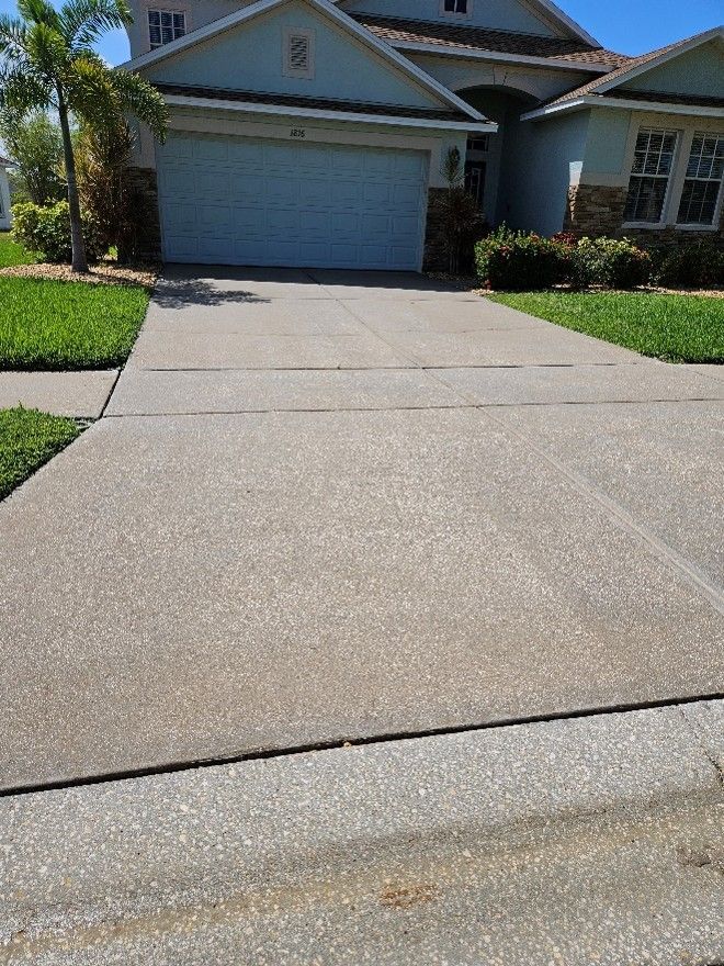 Suburban house with a two-car garage and a wide concrete driveway in bright sunlight