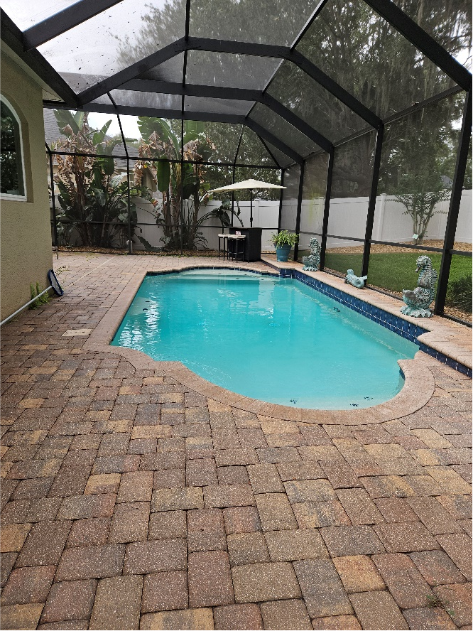Pool cage and paver deck in Riverview FL showing dust, dirt, and algae buildup before cleaning