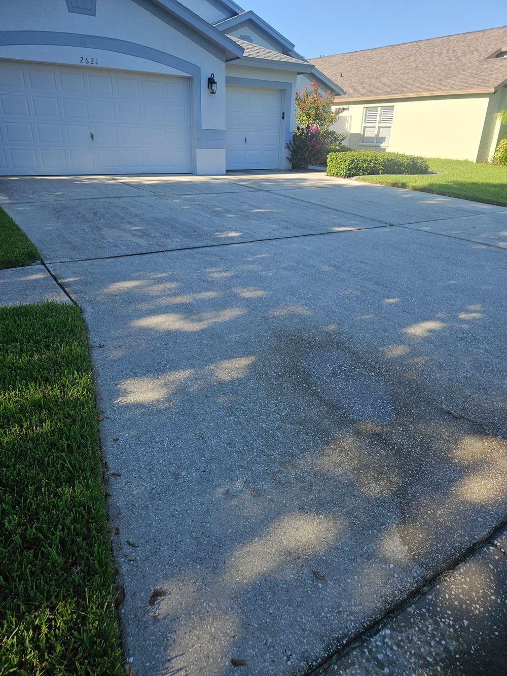 Driveway with dirt and buildup before pressure washing in Valrico, FL
