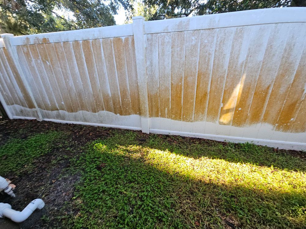 Heavy orange algae buildup on a vinyl fence in Brandon, FL
