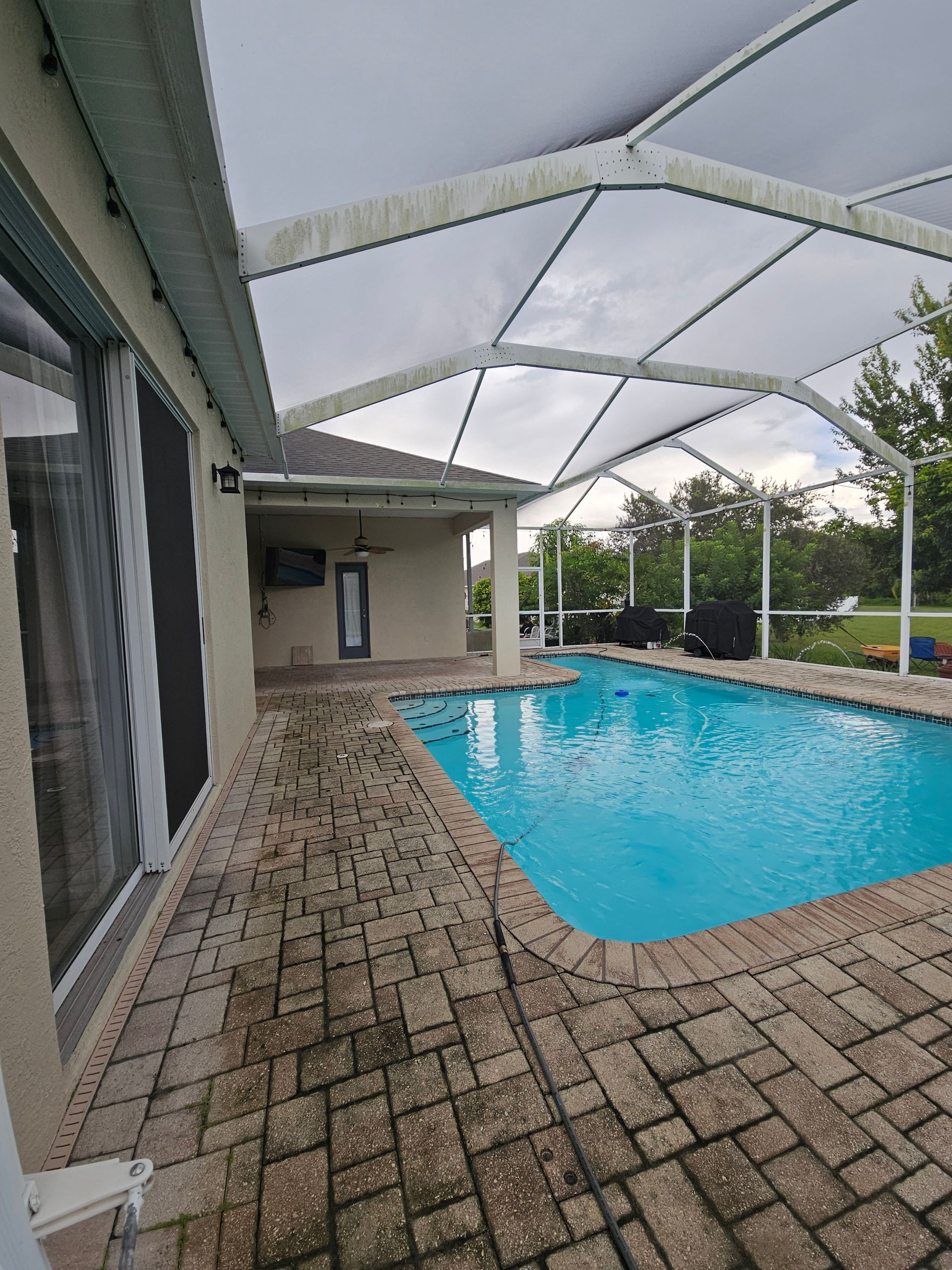 Pool cage and paver pool deck before cleaning in Riverview, FL