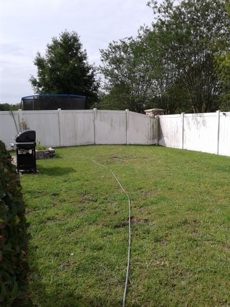 White vinyl fence with algae staining before cleaning in Ruskin FL