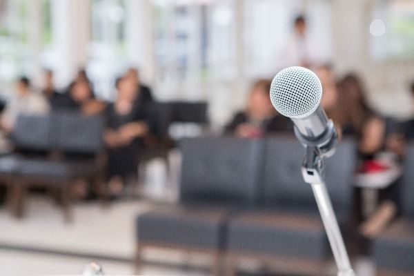 a microphone is sitting on a stand in front of a crowd of people .