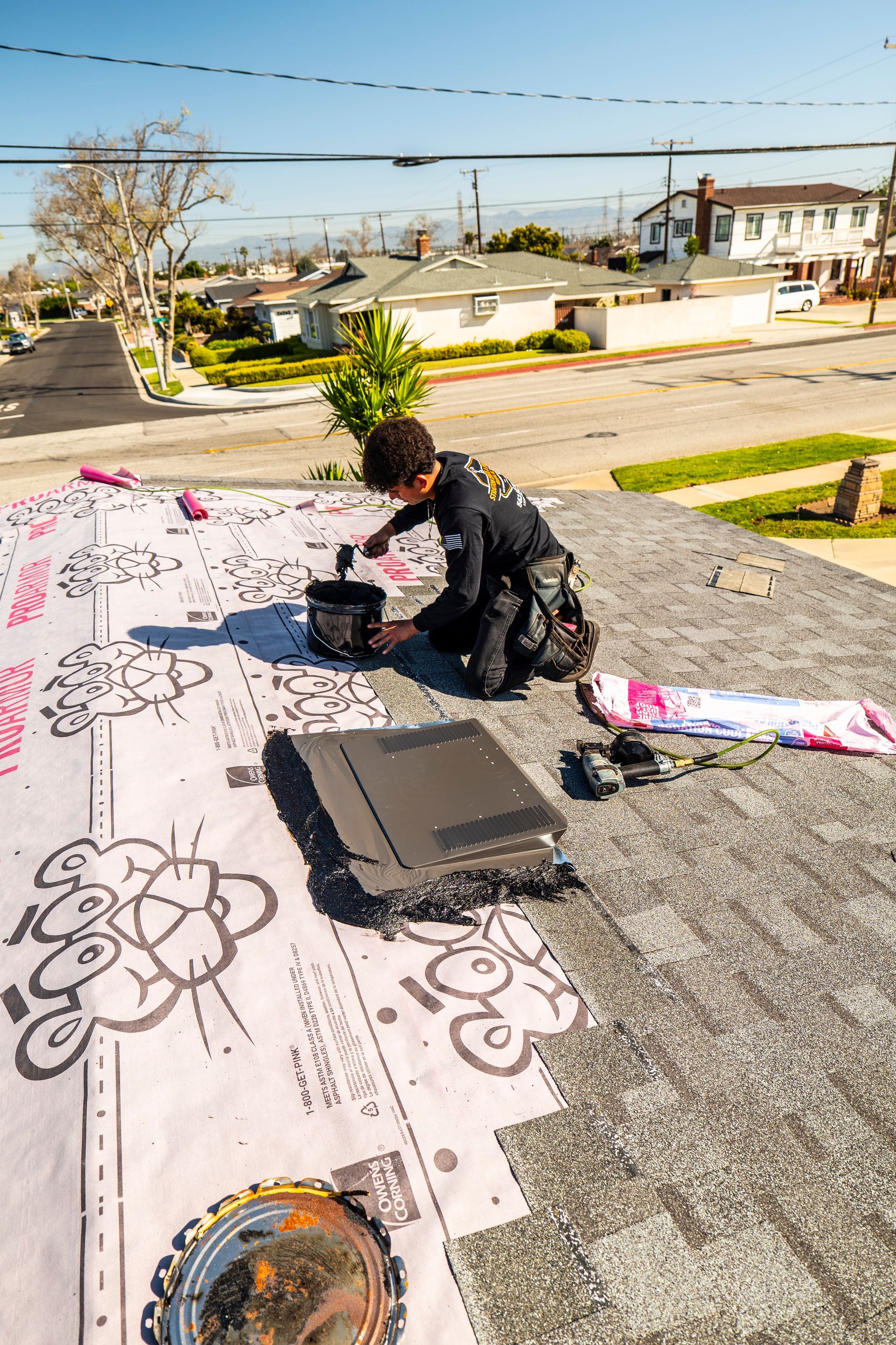 A man is working on the roof of a house.