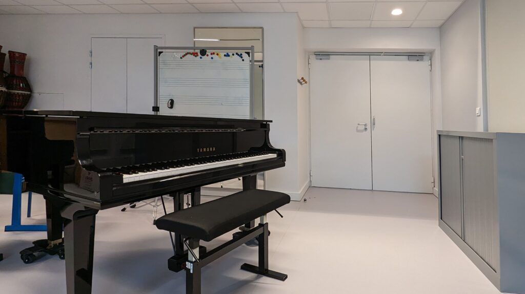 A piano is in a room with a bench in front of it