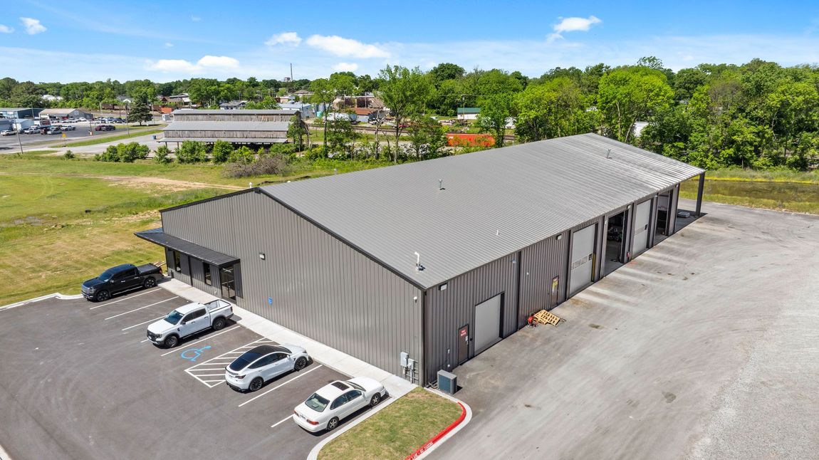 Drone View of a gray metal shop building and parking lot manufactured by Quality Metal Building Systems