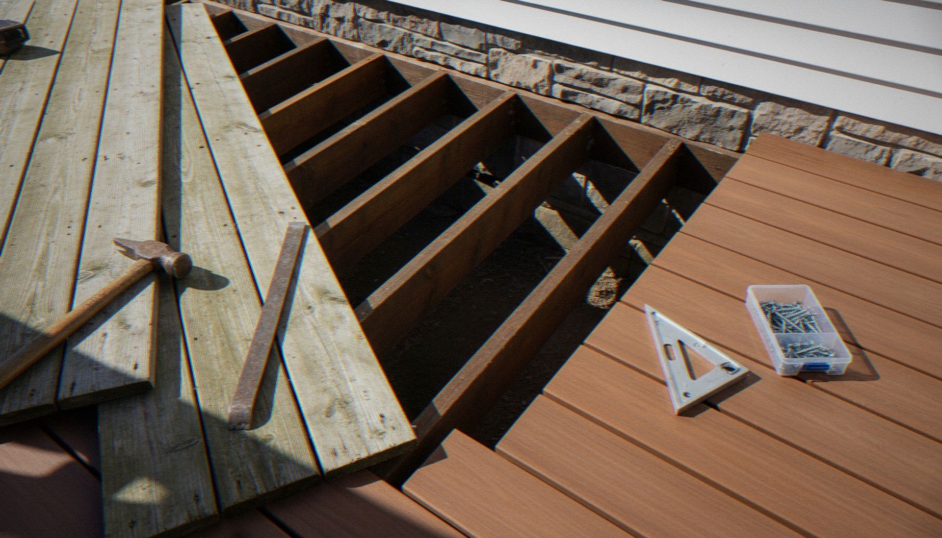 Deck under construction with exposed joists, wood planks, and tools laid on the surface Deck under construction with exposed joists, wood planks, and tools laid on the surface