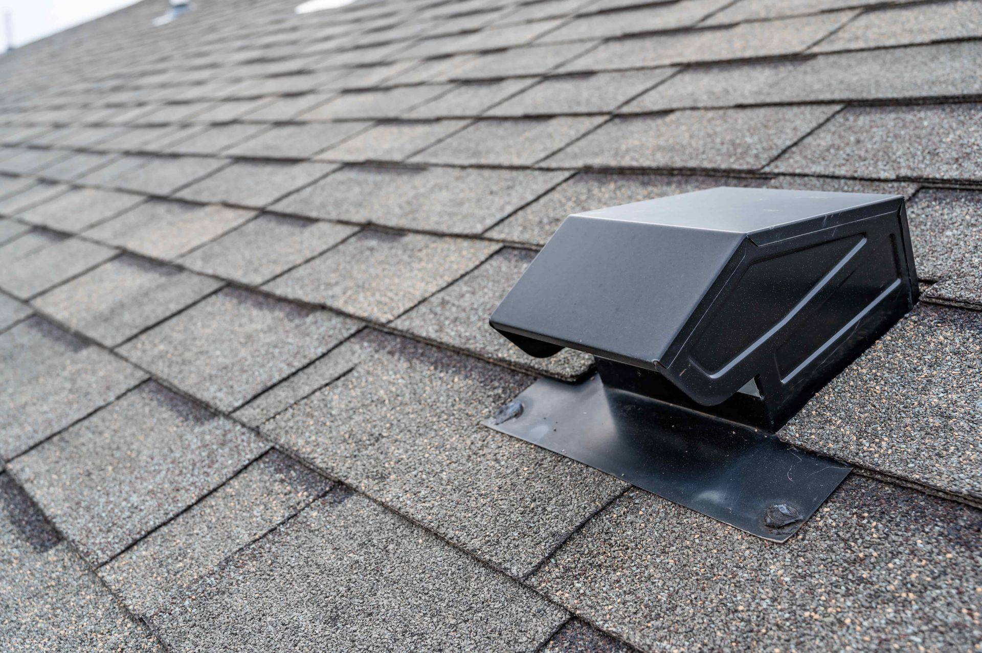 A close up of a roof with a vent on it.