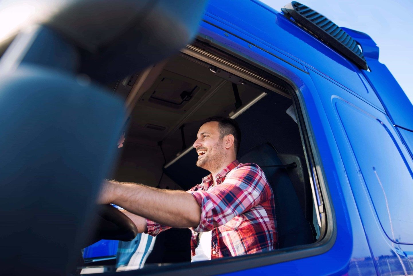 smiling truck driver has trucking insurance