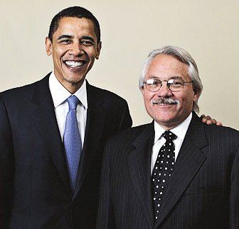 Two men in suits and ties are posing for a picture