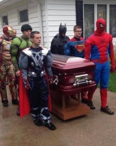 People dressed up in different super hero costumes carrying casket of loved one at Torres Cremation and Burial Services CA