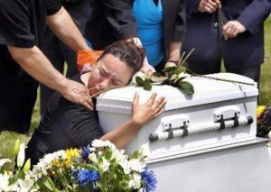 Mother hugging child's casket saying goodbye at Torres Cremation and Burial Services CA