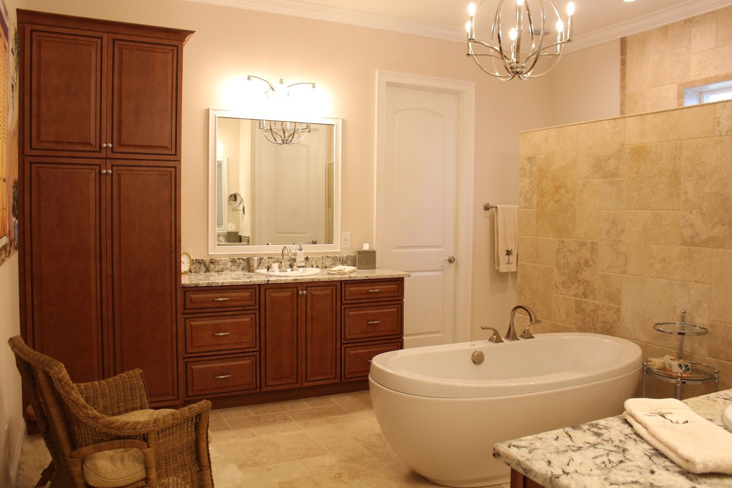 Spacious beige bathroom with double vanity, large mirror, freestanding tub, and glass shower enclosure