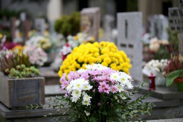 Colorful floral arrangements on tombstones in a cemetery.