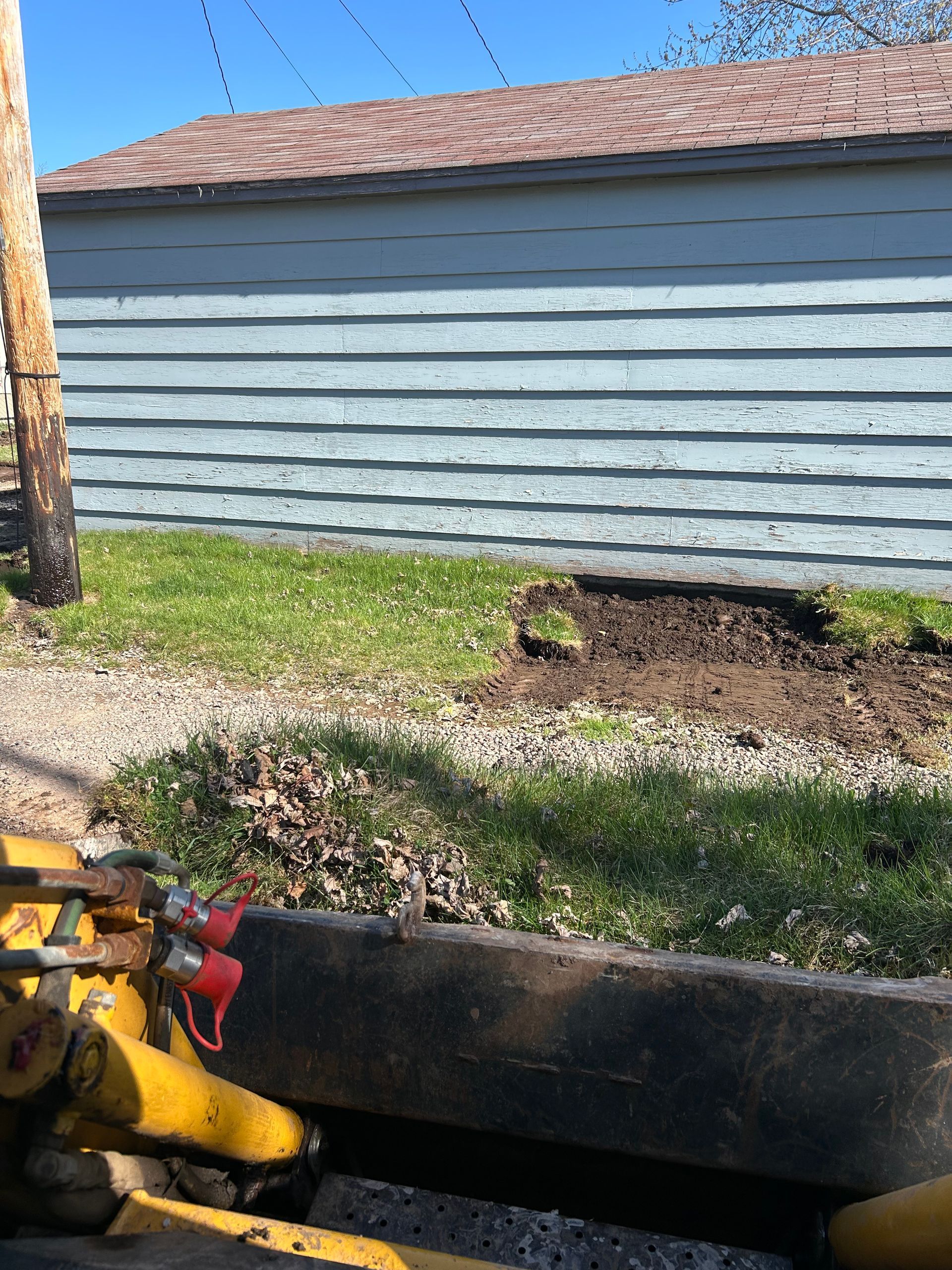 A yellow tractor is parked in front of a house.