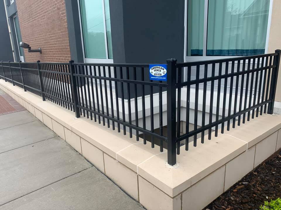 a black fence is surrounding a ramp in front of a building .