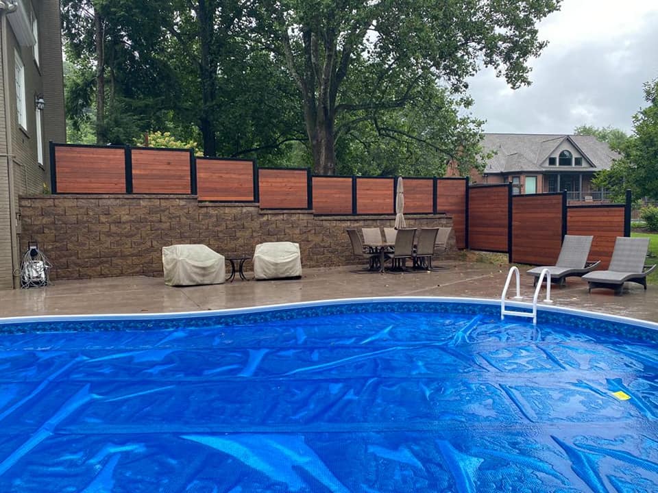 a large swimming pool with a wooden fence surrounding it .