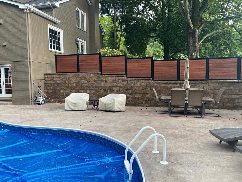 a large swimming pool with a wooden fence surrounding it .