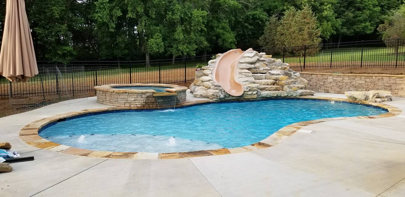 a large swimming pool with a water slide in the backyard .