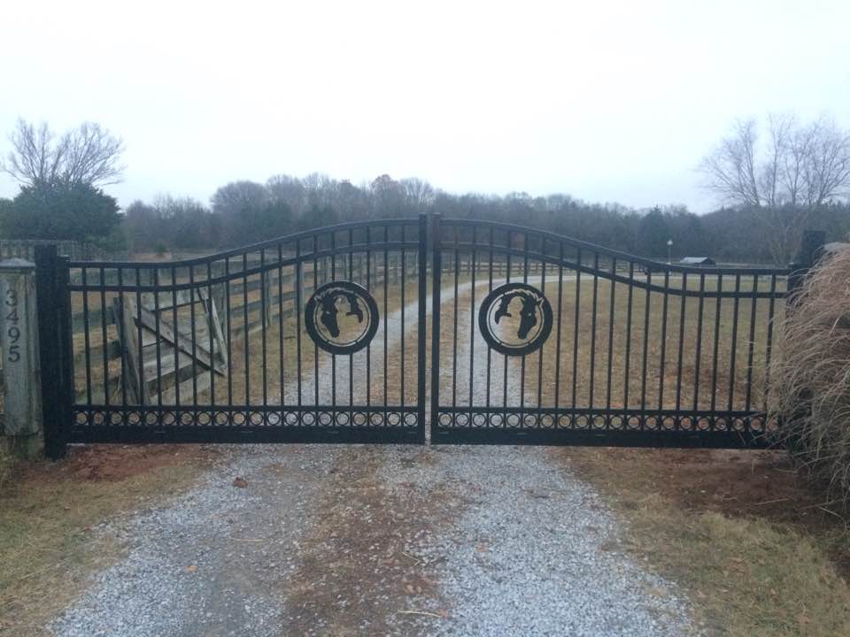 a wrought iron gate is sitting on the side of a gravel road .