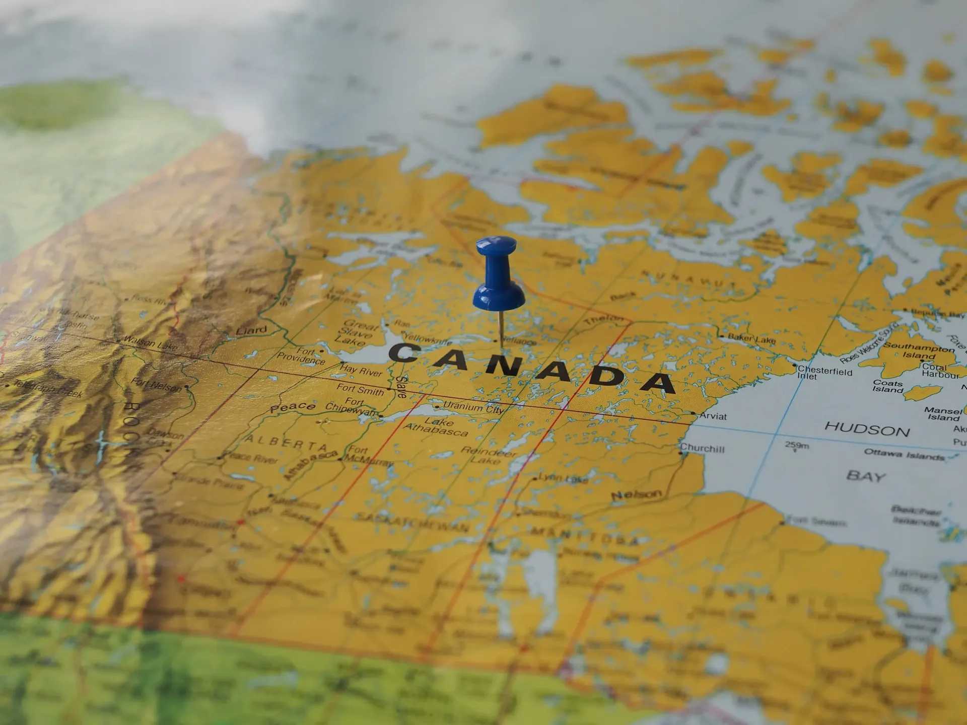 Blue pushpin marking Canada on a map of North America