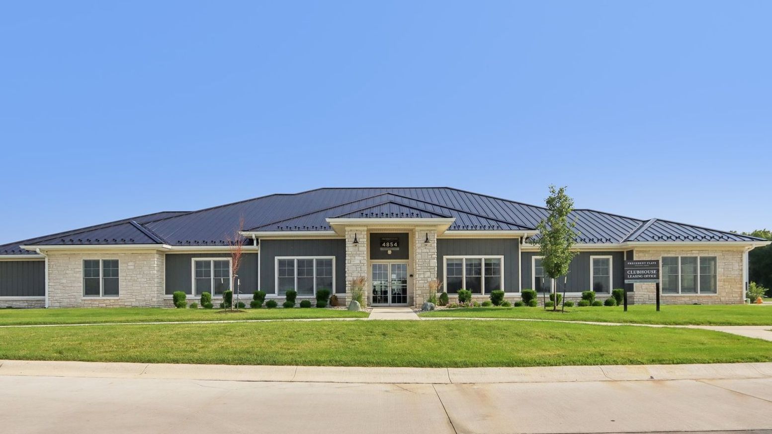 A large house is sitting on top of a lush green lawn.