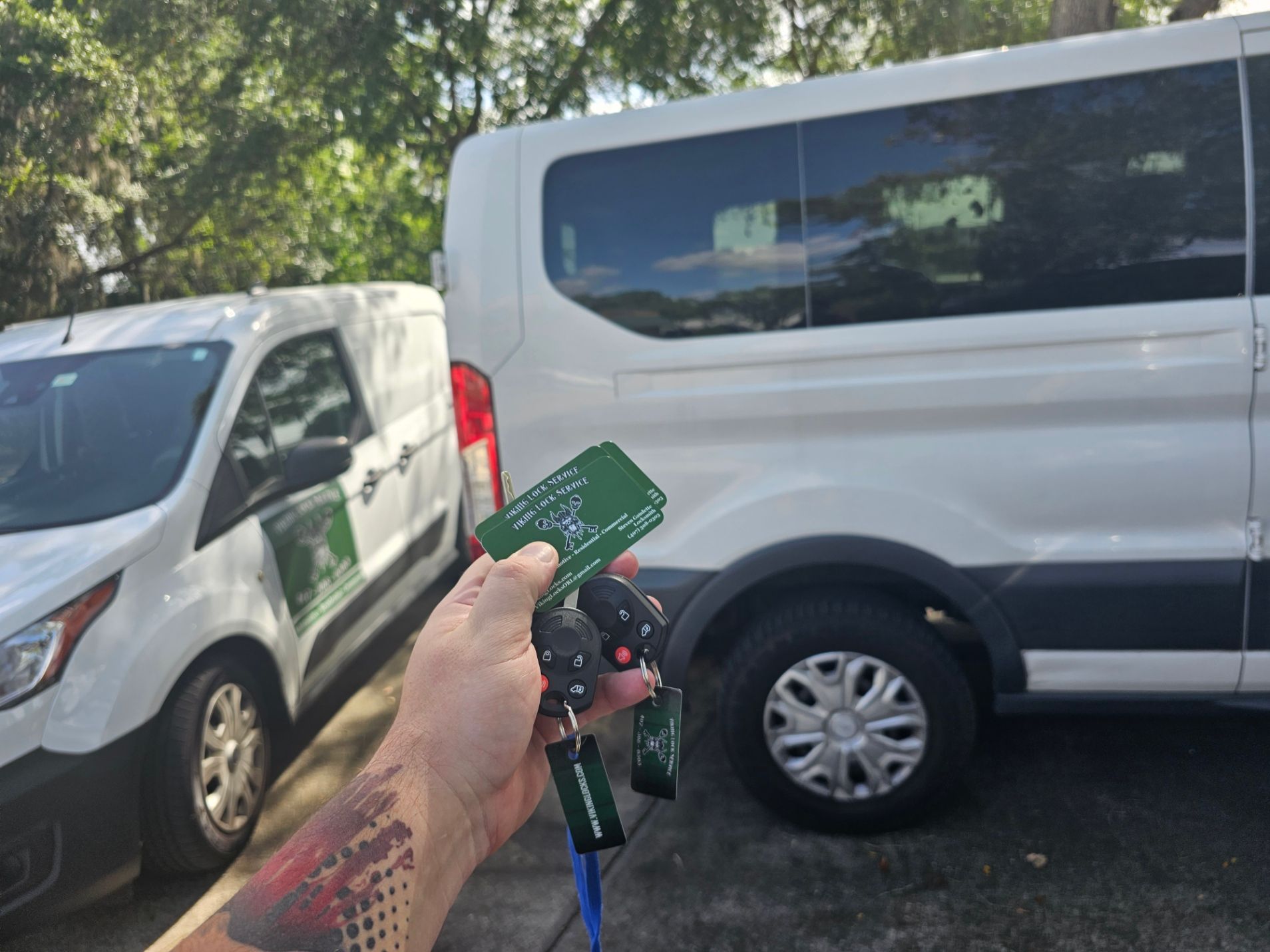 A person is holding a key in front of a white van